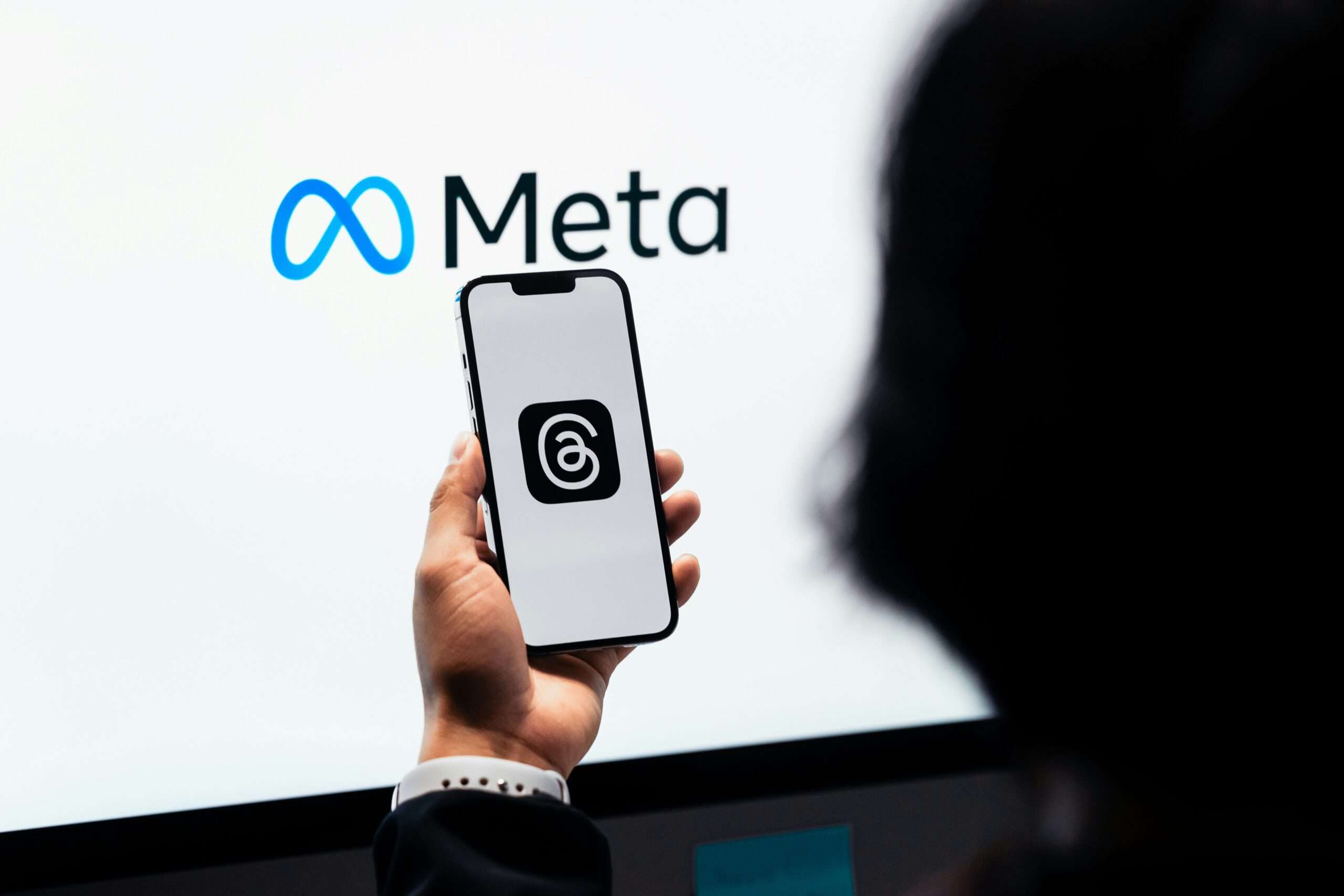 En hånd som holder en smarttelefon med Meta Platforms-logoen – illustrasjon til analysen av META-aksjer